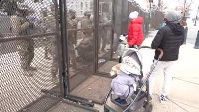 A four year old boy gives DC National Guard members cookies