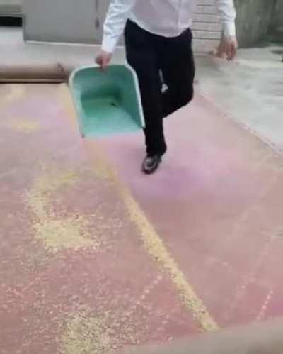 How this man picks up grains from a tarp