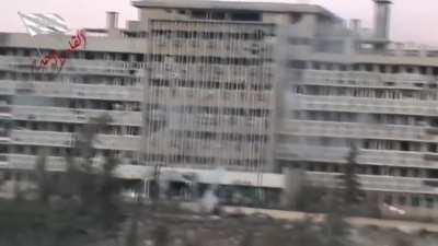 FSA forces suppress the windows of SAA controlled al-Kindi Hospital while a BMP moves in to unload infantry while supported by a T-72 - Aleppo - 12/9/2013