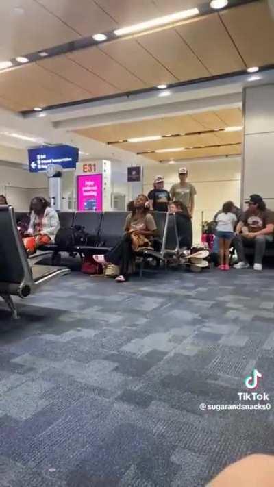 Lady irritates airport by singing at the top of her lungs.