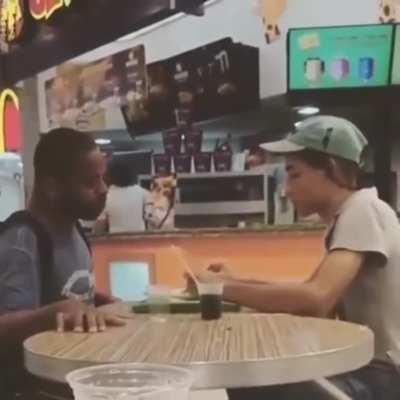 McDonald's employees helping a disabled man eat so he doesn't have to do it himself.