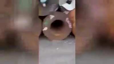 Guy tries to stop what looks like to be a heavy Cylinder of some sort