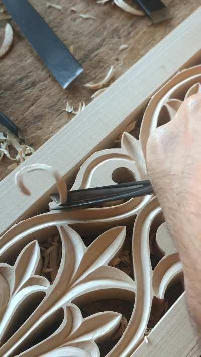 Woodcarver works on decorative linden panels