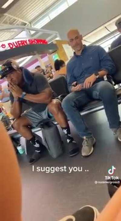 Bro gets upset when someone sits next to him at the airport terminal.