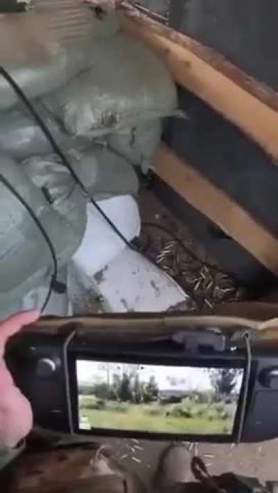 Ukrainian soldier remote operating a machine gun with a Steam Deck gaming system.