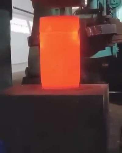 Compressing hot metal with hydraulic press...