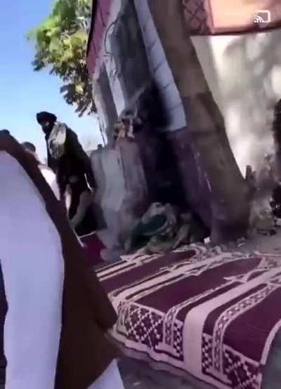 Taliban fighters assaulting a Hazara man trying to get to the airport and firing warning shots