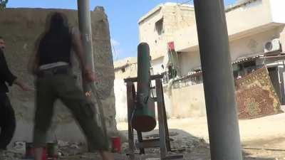 FSA fighters using a container flavored with vegetable oil against Assad regime positions