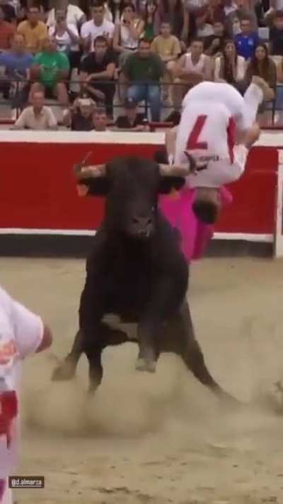 Man does a backflip over a live charging bull