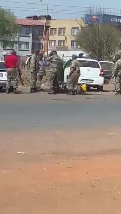 South African soldiers beating up and then berating a carjacker who had stolen one of their comrades' personal vehicles. 