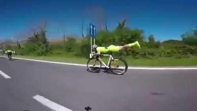 This cyclist unclips from his pedals, lies down on the seat and stretches out to achieve ultimate aerodynamic efficiency and overtake others.