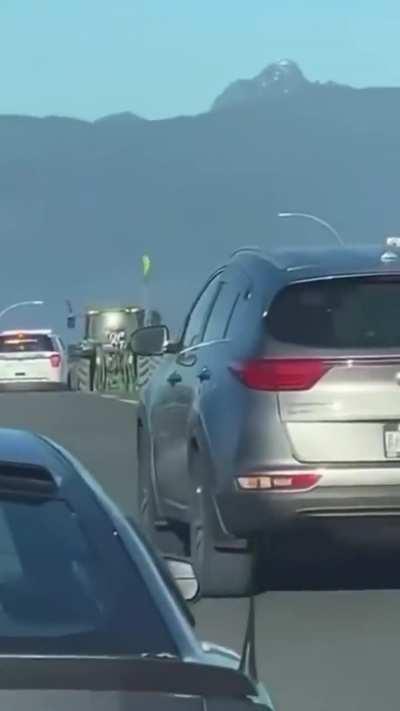 Protesting tractor driver tries to run police off the highway in BC, Canada.