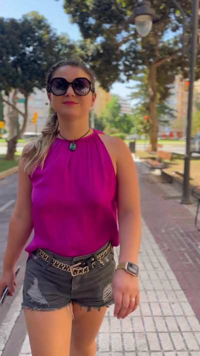 Walking the streets in a hot pink top.