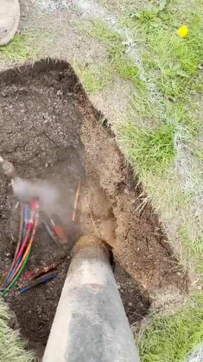 Digging out a connection pit for repairs.