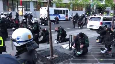 Montrealers think the police gets one one knee as sign of compassion only to realize they are putting on gas mask as shooting is about to start