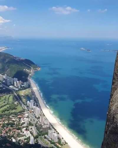 A tourist sitting on top of the Pedra da Gávea Mountain, Brazil