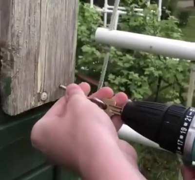 Using a power drill and a key to easily screw in a hook