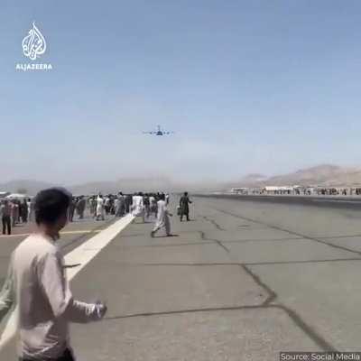 Afghans who cooperated with the US occupation are desperately fleeing for their lives at Kabul airport. Some are holding on to the outside of a US transport plane, and are later seen falling down in mid air.