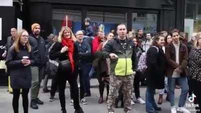 Woman with wild hair disrupts an acoustic street performance