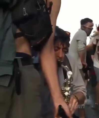 Man with saxophone plays during a protest in Chile