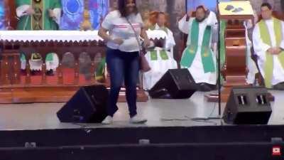 Woman pushes Priest off stage during a mass live broadcast
