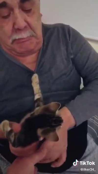 Old man crying while the cat he founded on the street being adopted.