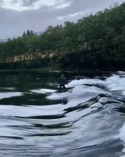 Surfing a river break in Norway