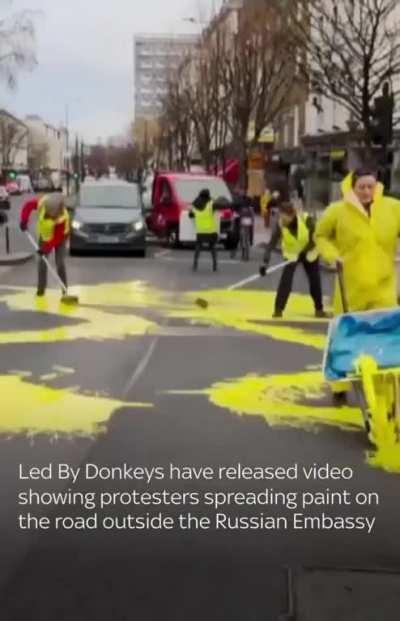 Four people have been arrested after Ukrainian flag was painted outside Russian embassy in London.