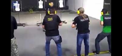 Guy acts as a none target in a live firing range police training.
