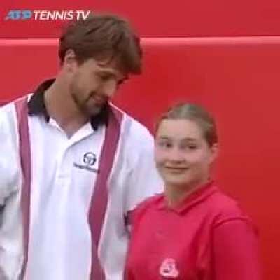 Wholesome moment between a tennisman and a ball catcher