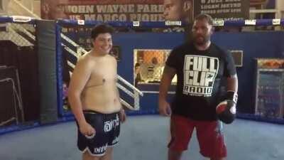 Chubby kid takes a gut shot from Mark Hunt one of the hardest punchers in UFC/MMA history and smiles like it wasn't shit