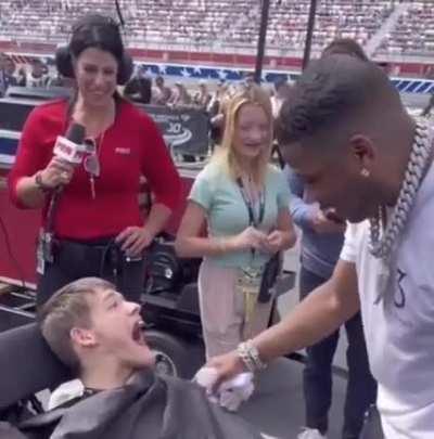 Nelly gives his jacket to a young man