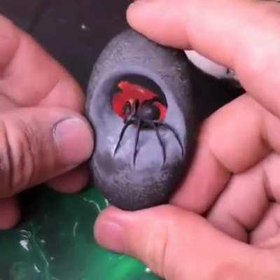 Carving a river stone into a Black Widow