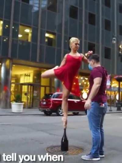 Ballerina balancing on a champagne bottle