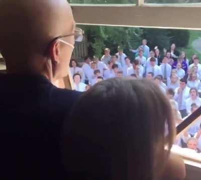 Students gather outside the home of their cancer-stricken teacher to sing for him.