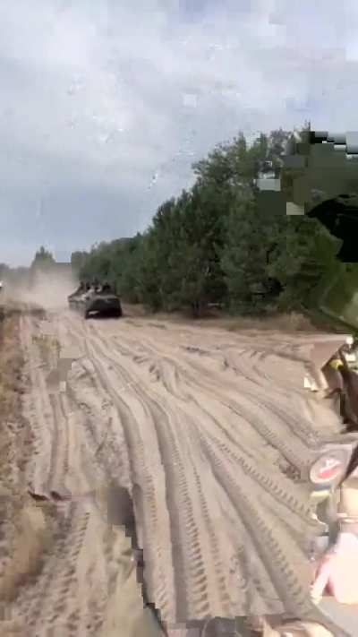 Ukrainian soldiers riding on armored vehicles greet each other 