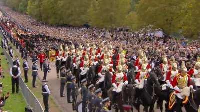 A guard gets slapped by a horse during the funeral procession of the queen