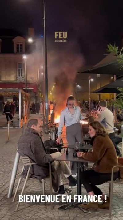 People dining at a cafe while the French pension reform take place