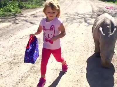 Oh this? It’s just a girl walking with her baby rhino friend. Just keep scrolling.