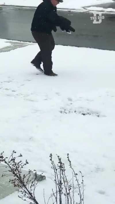 A dad teaching his kid to make snow angel