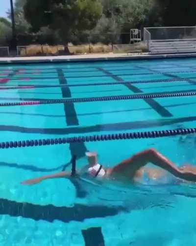 Olympic Gold Medalist, Katie Ledecky, swims with a glass of chocolate milk on her head