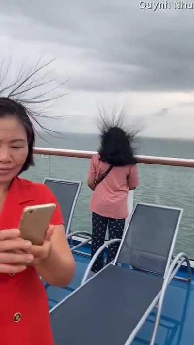 Peoples hair raising on a cruise ship caused by lighting about to strike them