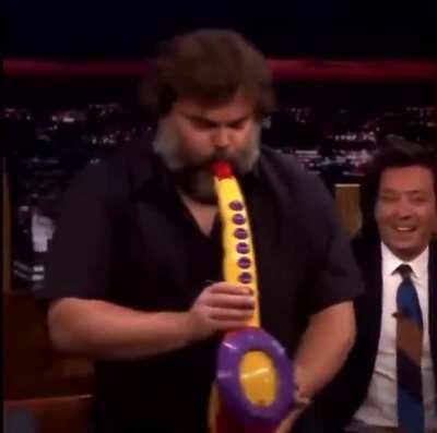 Jack Black playing a toy Saxophone as if it was the real thing