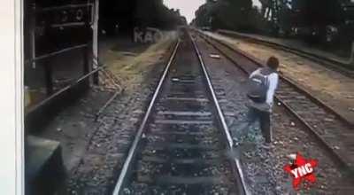 Crosses in front of train on to other train tracks