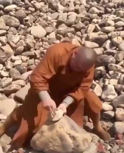 Shaolin monk strikes a rock with his iron fingers.