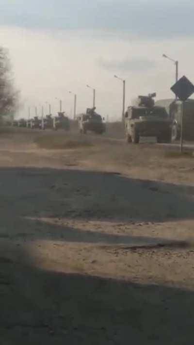 A Ukrainian citizen attempting to block a large convoy of Russian vehicles.