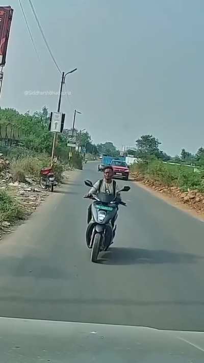 No helmet, and on top of it and phone in hand.