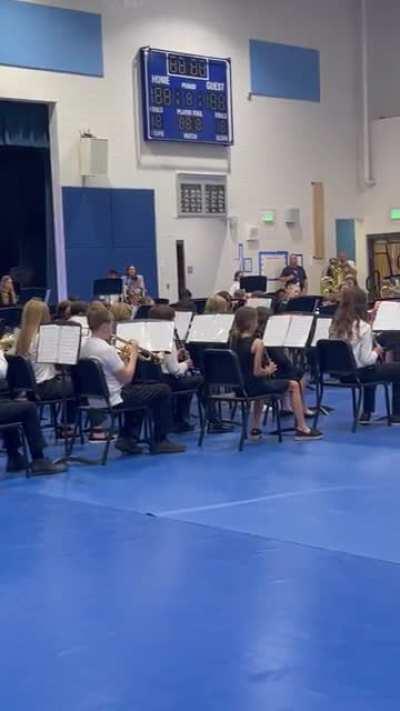 School band plays Jurassic Park theme with a guest conductor