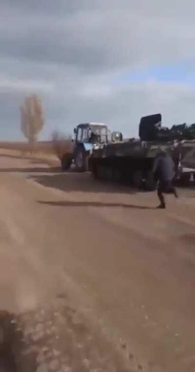 Ukrainian tractor taking a Russian MT-LB.