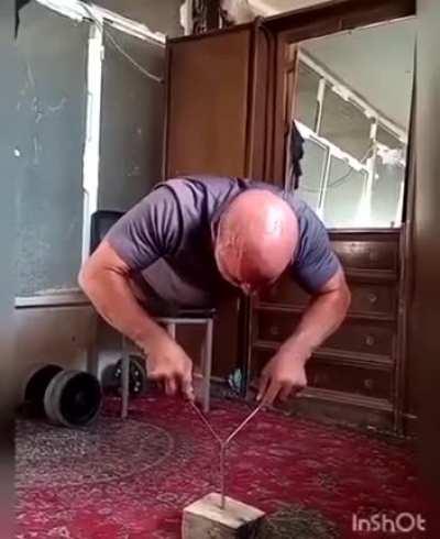 Man does push ups while balancing on the head of a nail